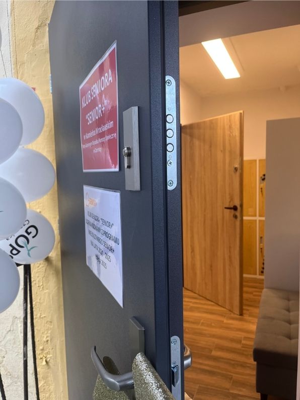 uchylone drzwi d klubu, obok balony z napisem GOPS