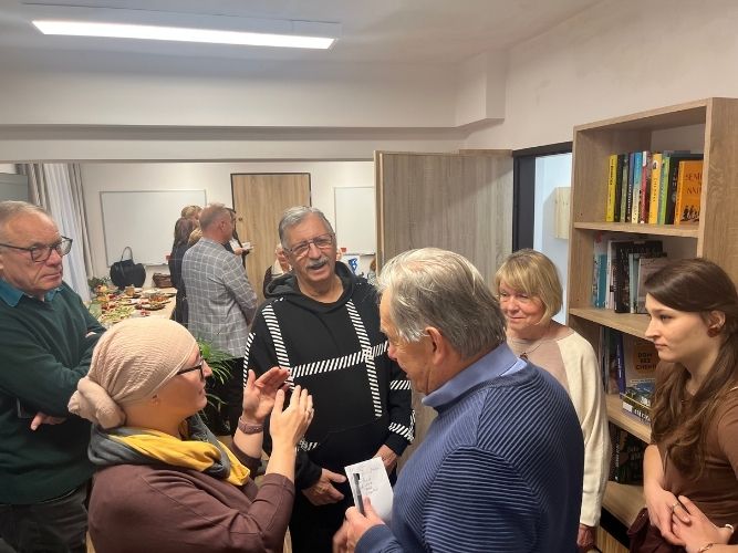 grupa rozmawiających ludzi stojących w kółku